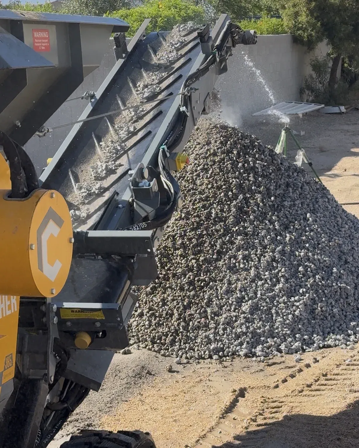 Concrete crusher conveyor creating reusable aggregate base
